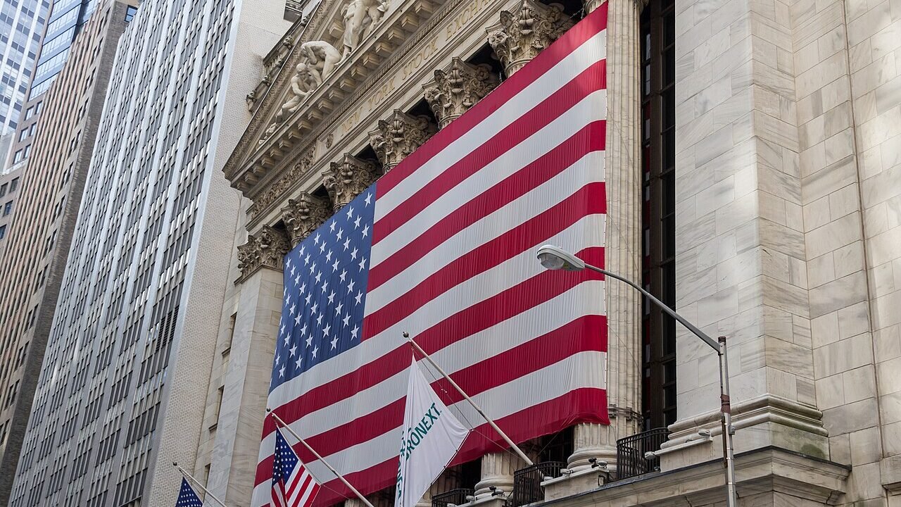 New York Stock Exchange facade draped with a large United States flag symbolising federal banking oversight