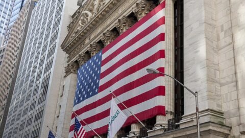 New York Stock Exchange facade draped with a large United States flag symbolising federal banking oversight