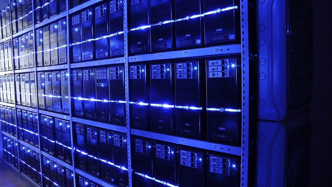 Rows of illuminated server racks inside a modern data centre representing AI infrastructure