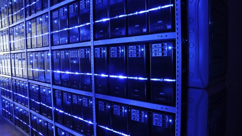 Rows of illuminated server racks inside a modern data centre representing AI infrastructure