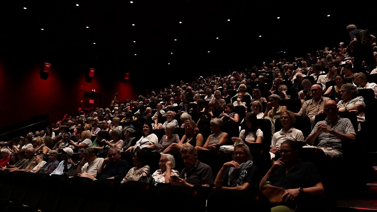 A festival audience inside a cinema auditorium during an evening screening