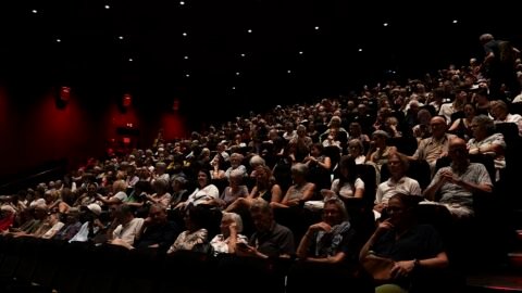 A festival audience inside a cinema auditorium during an evening screening