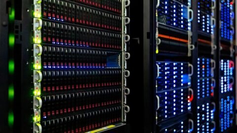 Rows of computer server racks with blinking lights in a data center